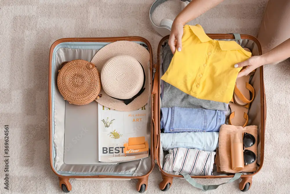 Packing Light for Travel: Woman packing suitcase at home. Travel concept