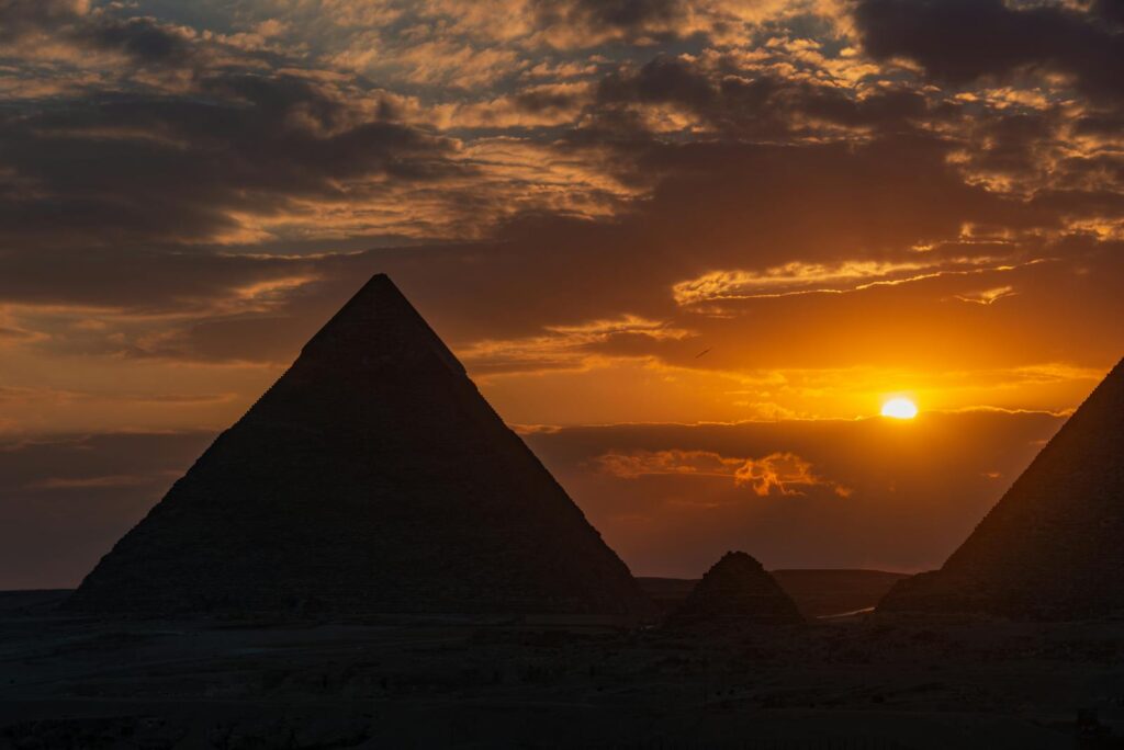 Breathtaking silhouette of Egypt's iconic pyramids at sunset.