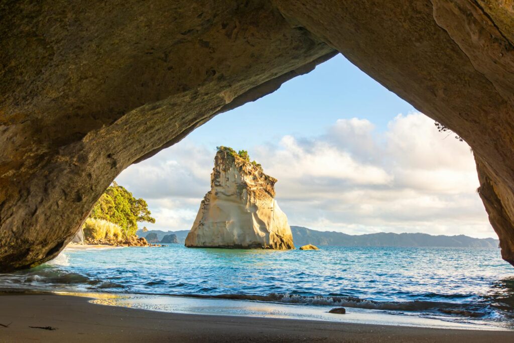 Scenic Road Trips in New Zealand: Scenic view of Cathedral Cove beach and rock formations in New Zealand.