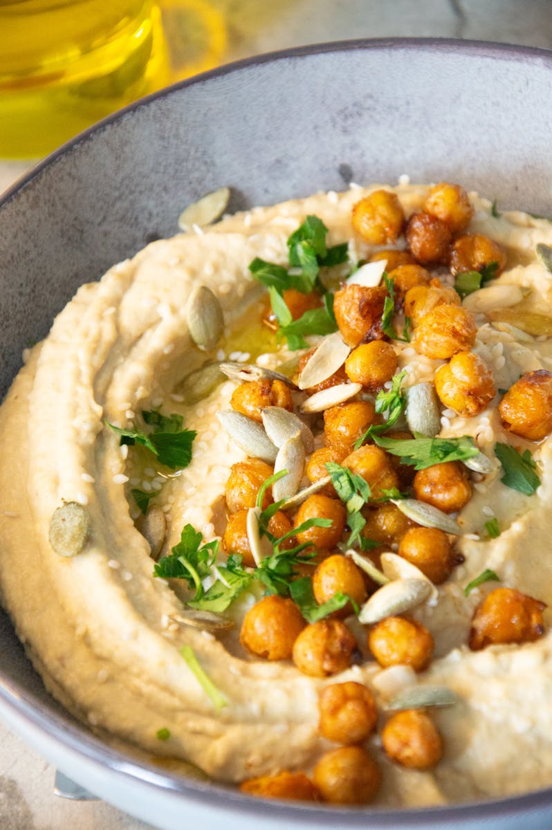 Creamy hummus topped with roasted spiced chickpeas and herbs.