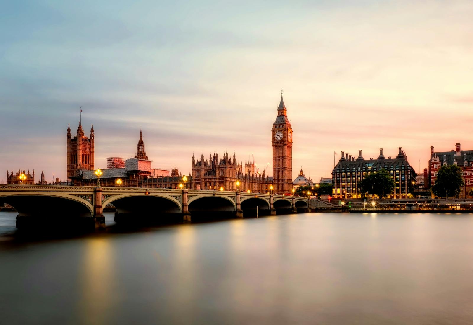 London travel tips: Scenic view of Big Ben and Westminster Bridge over the Thames River at sunset in London, UK.