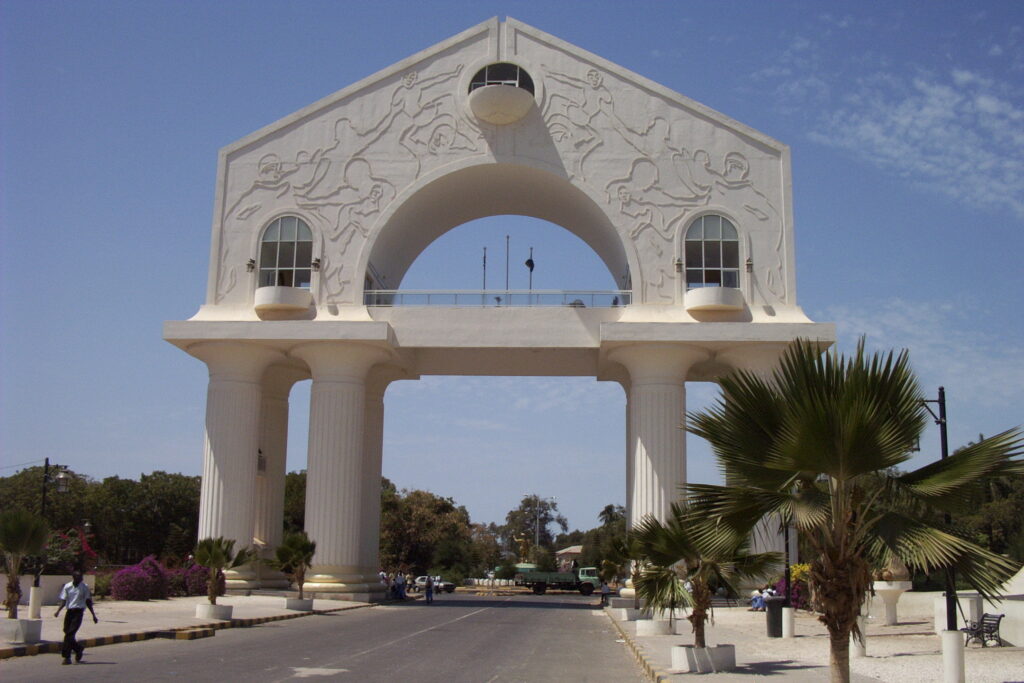 African Hidden Gems: Arch 22 gambia, white arch on an avenue