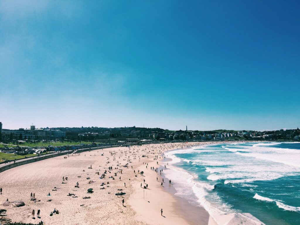 Best Beaches in Australia : bondi beach, a group of people standing on top of a sandy beach