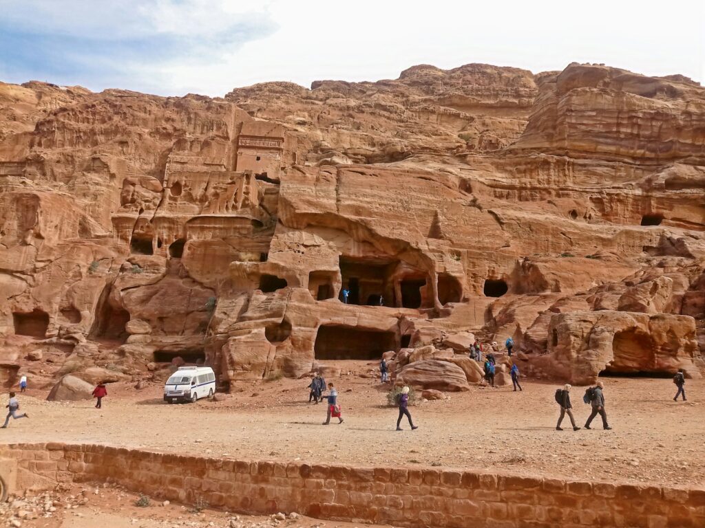 Petra Travel Guide: Street of Facades, a group of people walking around a desert area