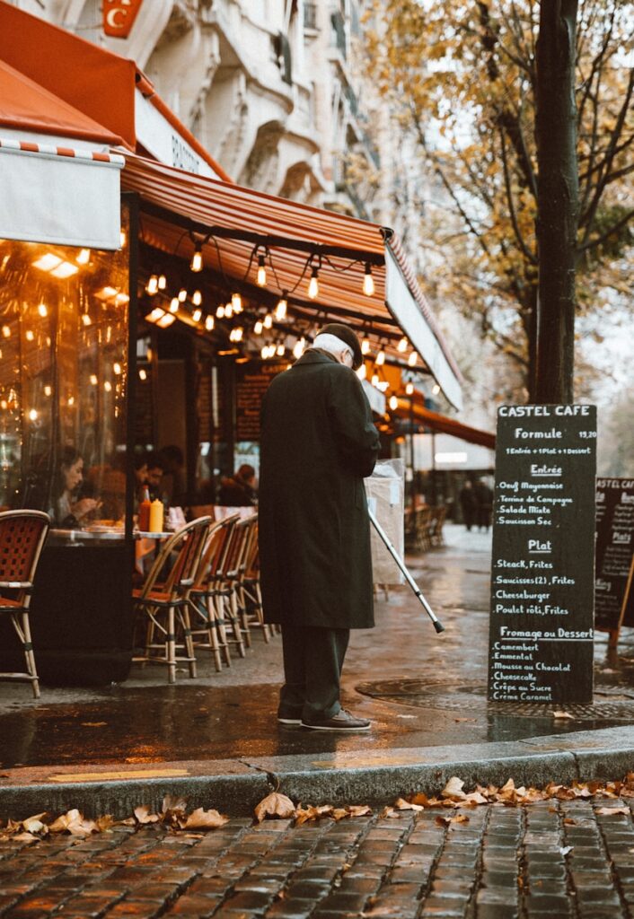 Paris on a Budget: man with walking stick standing near curb