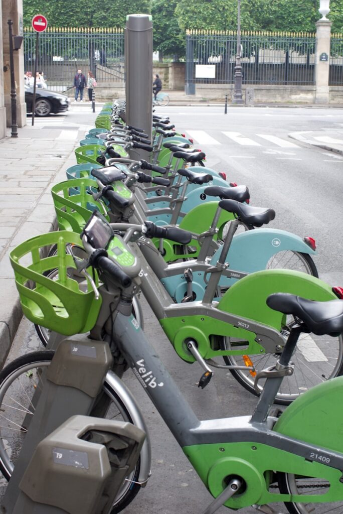 Paris on a Budget: vélib, a row of bicycles parked next to each other