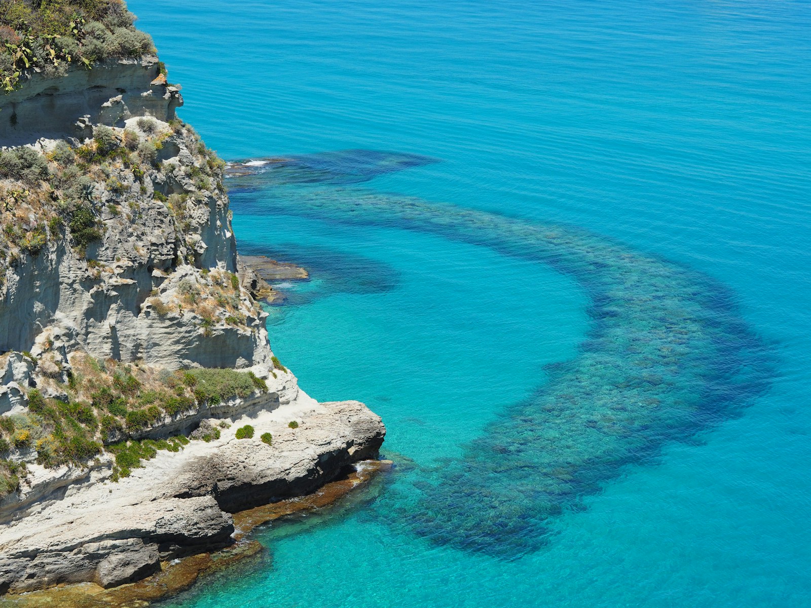 Hidden Gems in Italy: Tropea, white rock mountain and body of water