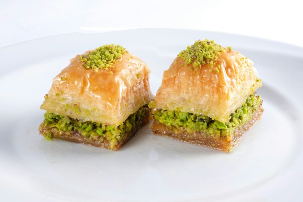 Authentic Middle Eastern Cuisine: Baklava, two brown bread on white ceramic plate