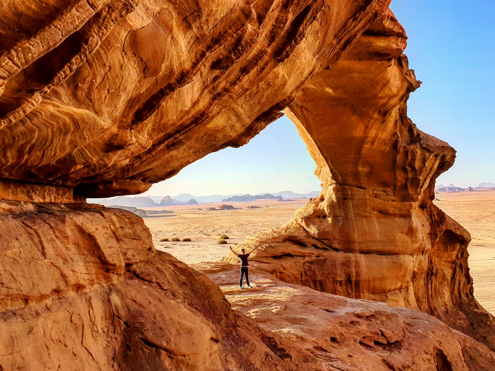 Best deserts to visit in the middle east: Wadi Rum, person standing on rock formation during daytime